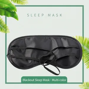 Black polyester sleep mask with dual elastic straps on a soft mint green leaf background