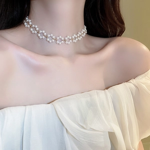 Gros plan du collier choker à fleurs de perles avec connecteurs dorés sur modèle