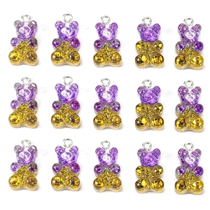 Detailed grid of 15 purple and yellow gradient glitter bear charms for DIY jewelry making