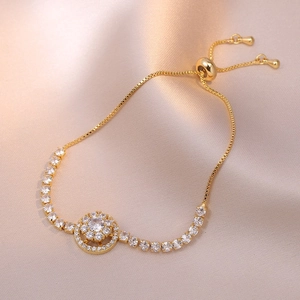 Close-up of golden adjustable flower bracelet with sparkling cubic zirconia on silk