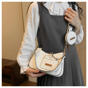 White crescent crossbody bag with mini round coin purse and chain detail on female model