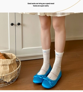 Detail of floral knit crew socks featuring a cute blue bow accent and mesh texture