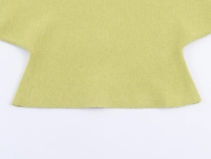 Detail of lime green knit sweater showing fine texture and hemline craftsmanship