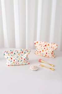 Dettaglio di trousse in tela con pois disegnati a mano e motivi a piccoli cuori