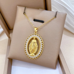 Detail of gold oval pendant with Virgin Mary relief and sparkling crystals in gift box