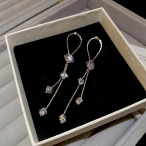 Boucles d'oreilles pendantes en argent avec quatre zircons carrés sur velours noir