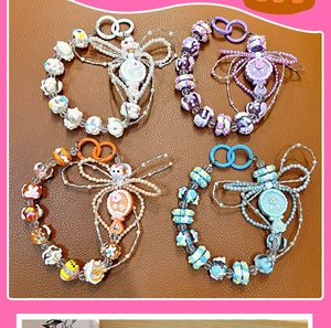 Vue détaillée de quatre chaînes de téléphone perlées avec mini pendentifs miroir.