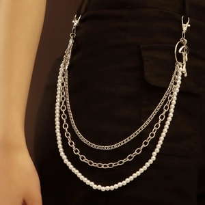 Three-layer metal waist chain with pearls and mushroom pendant on black denim