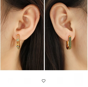 Detailed view of U-shaped gold earrings with micro-pave colored zircon crystals