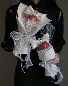 Detail of Christmas apple bouquet with white snowflake wrapping and elegant silk ribbons
