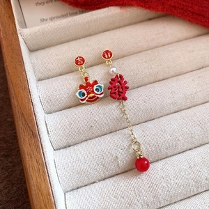 Detail view of asymmetric Chinese style lion and pearl earrings in a jewelry box