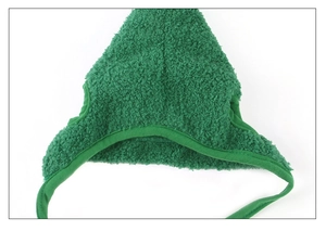 Close-up of green plush Christmas pet hat showing fuzzy lamb wool texture and ear flaps