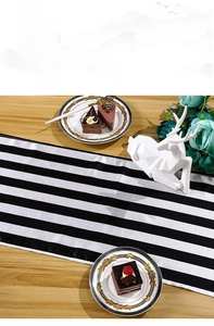Detail of modern black and white striped table runner on wooden dining table