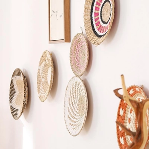 Artistic hand-woven boho round straw wall baskets for ethnic interior wall decor