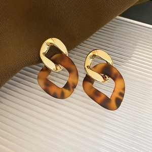 Detail of leopard print resin hoops with gold metallic studs and tortoise shell texture