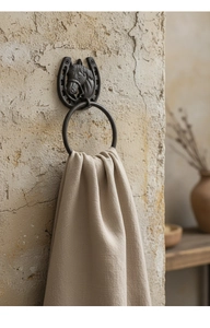 Detail of vintage cast iron horseshoe towel ring with horse head sculpture on wall