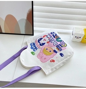 Detail of white canvas tote with purple handles and cute cartoon character graphics