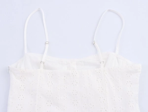 Detail of white midi dress showing floral eyelet embroidery and adjustable straps