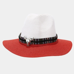 Detail of red and white woven Panama hat with ethnic band and silver bull head ornament