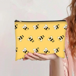 Detailweergave van de gele canvas tas met bijenprint en zilveren ritssluiting