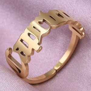 Macro shot of gold stainless steel adjustable ring featuring gothic BIRTH hollow engraving