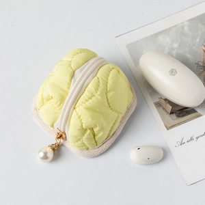 Detailed shot of yellow quilted cotton storage pouch with decorative pearl zipper charm