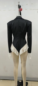 Detail of slim fit black blazer bodysuit featuring white lace patchwork and ruffled edges