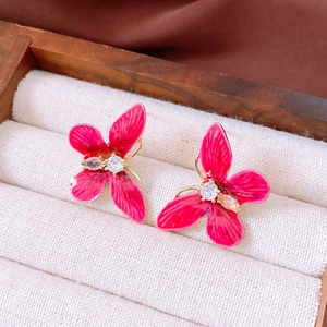 Gros plan détaillé des boucles d'oreilles papillon rose vintage avec accents en zircon