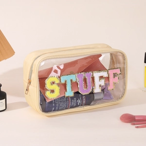 Detail of transparent PVC makeup bag featuring colorful sequin STUFF lettering patches