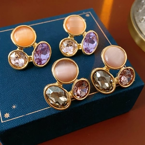 Detailed macro view of vintage gold-plated earrings with cat eye stones and crystals