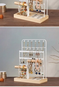 Close-up of white metal jewelry organizer with wooden rod and tray for accessories
