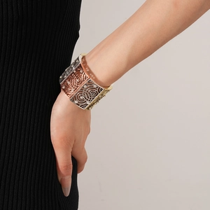 Detailed view of vintage multi-color metal bracelet with cutout swirls and rhinestones