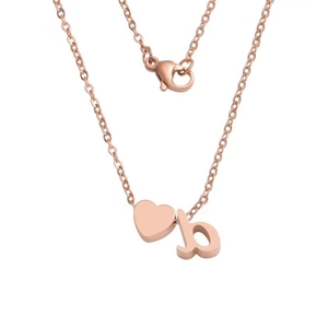 Macro shot of rose gold heart pendant and lowercase letter b charm on a fine chain