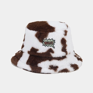 Detailed view of plush cow print bucket hat featuring a WHAT lightning patch on soft faux fur