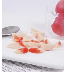 Close-up of 2cm miniature realistic peeled apple slices on a decorative ceramic plate