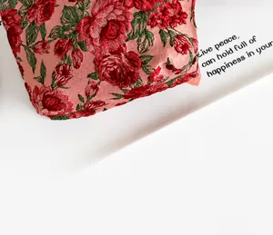 Dettaglio del tessuto jacquard vintage con motivo di rose rosse e trama a rilievo