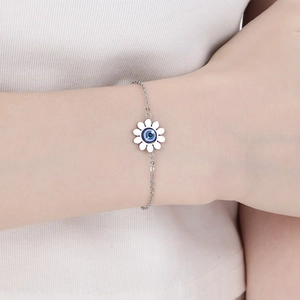 Gros plan d'un bracelet tournesol argenté avec opale evil eye sur le poignet d'une femme