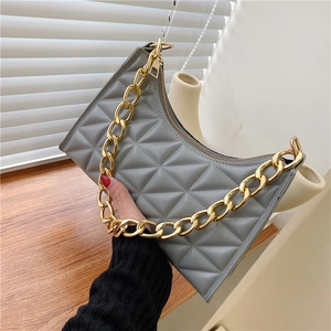Detail of grey quilted shoulder bag featuring a chunky gold chain strap and zipper