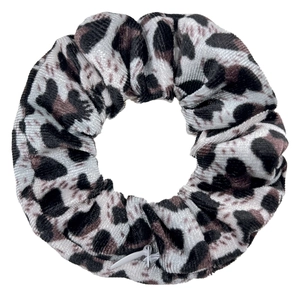 Detailed close-up of velvet leopard print scrunchie with zipper pocket design