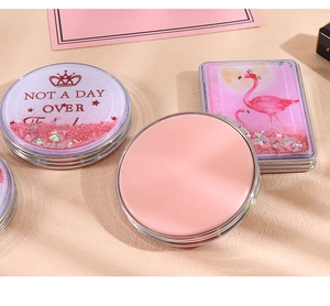 Detail of pink glitter quicksand mirrors with flamingo and crown designs in silver frames