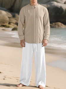 Détail de l'ensemble chemise en lin beige et pantalon blanc pour homme sur une plage
