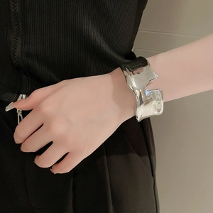 Close-up of silver irregular liquid metal cuff bracelet with wide geometric texture