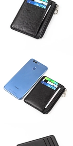 Slim black lychee leather card holder with zipper pocket shown next to phone for size