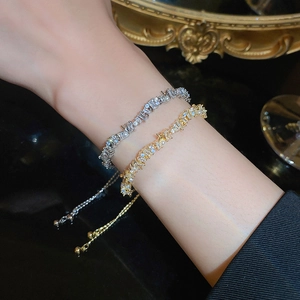 Close-up of adjustable gold and silver zircon bracelets worn on a model's wrist