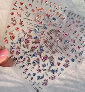 Dettaglio di adesivi per unghie a rilievo rosa champagne con eleganti motivi floreali