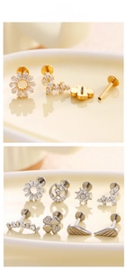 Macro shot of titanium four-leaf clover and feather labret studs with cubic zirconia