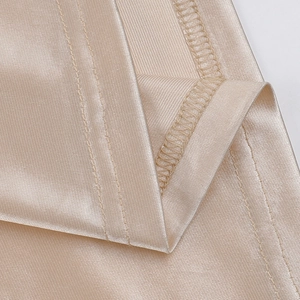 Detail of champagne satin fabric showing fine stitching and smooth silk-like texture