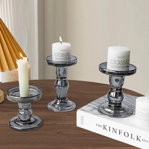 Three-piece set of smoky gray glass pillar candle holders in various heights for home decor