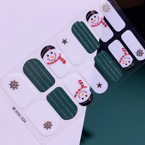 Détail de stickers à ongles de Noël avec motifs bonhomme de neige et flocons en vert et blanc