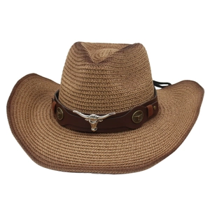 Close-up of brown straw cowboy hat featuring leather band and silver bull head emblem